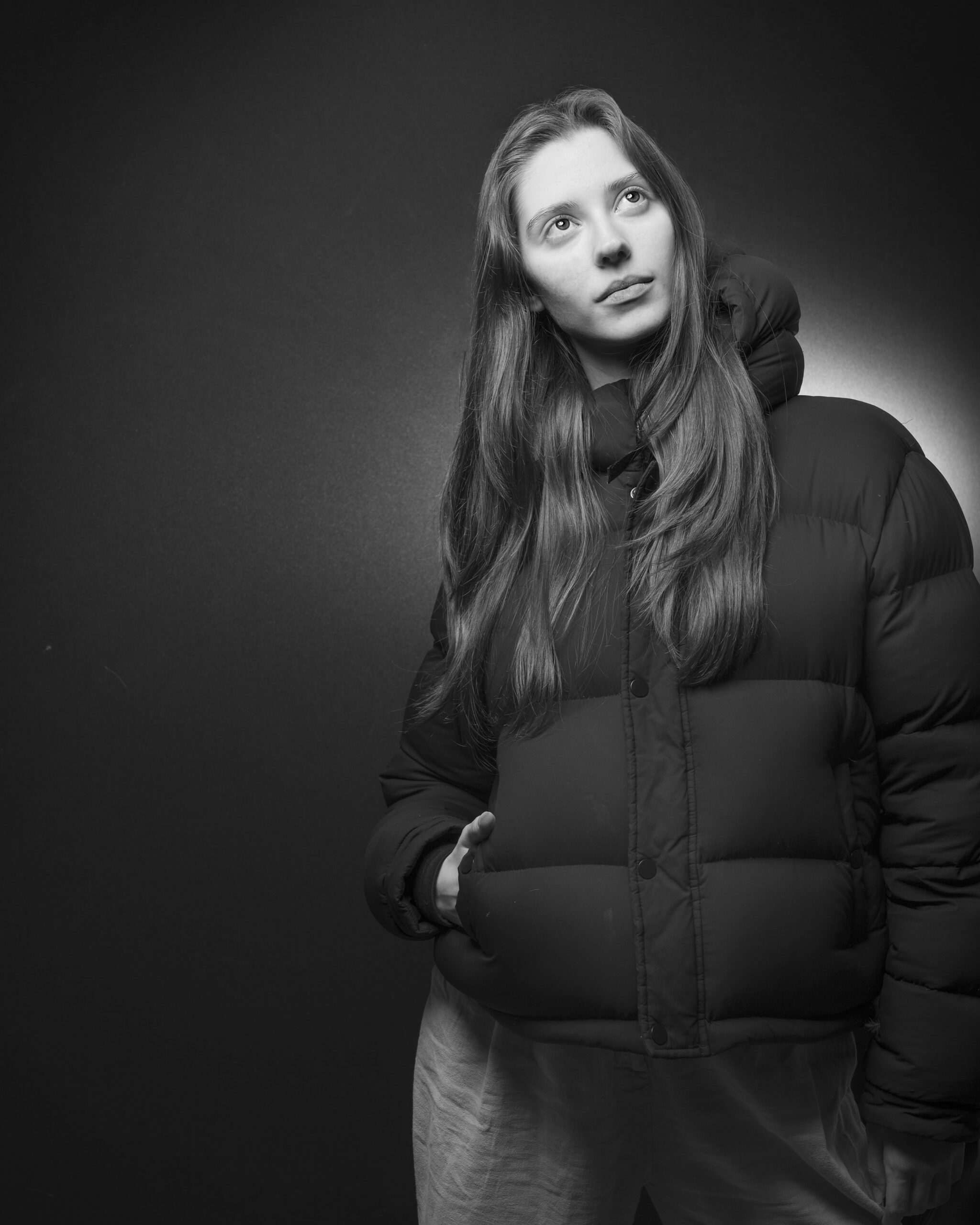 A black-and-white depiction of a woman posing in a black jacket.